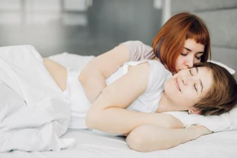 Attractive red-haired girl waking her sister up Stock Photos