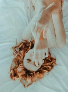 Attractive redhead model on bed Stock Photos