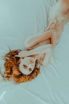 Attractive redhead model on bed Stock Photos