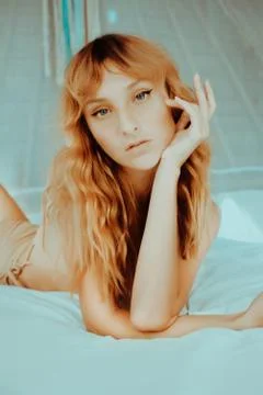 Attractive redhead model on bed Stock Photos