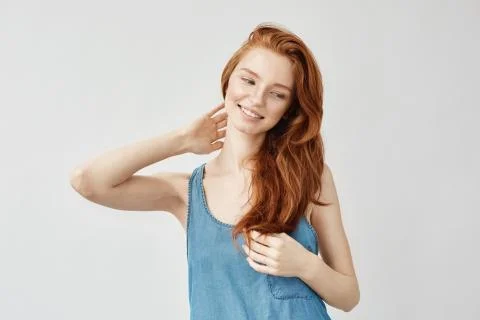 Attractive redhead model smiling touching hair Foto stock