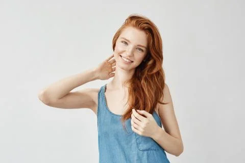 Attractive redhead model smiling touching hair Photos