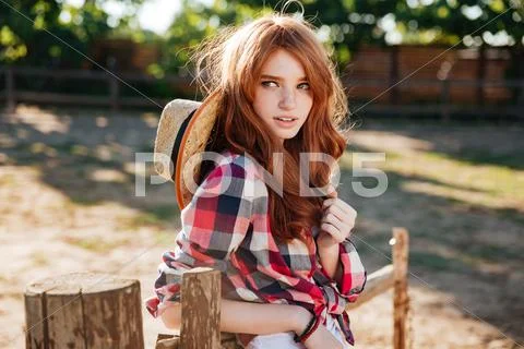 Attractive redhead young woman cowgirl standing outdoors Stock Photos