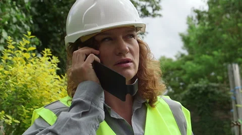 Attractive redheaded female architect / engineer speaks on cell phone Stock Footage 52300140