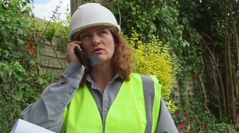 Attractive redheaded female architect / engineer speaks on cell phone Stock Footage 52300399
