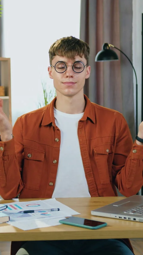 Attractive relaxed 25-aged blond male worker in glasses enjoying harmony and sil Stock Footage 325335673