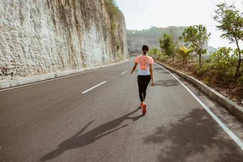 Attractive runner taking break after jogging outdoors Stock Photos