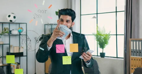 Attractive satisfied successful bearded worker standing near glass wall with Stock Footage 157936068