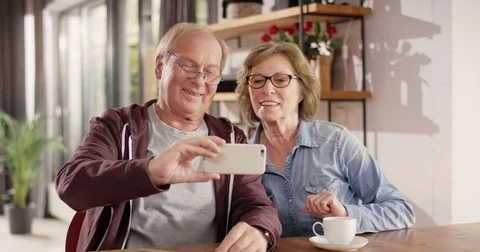 Attractive Senior Couple make a Face Time Call with Smartphone Video stock 82172433