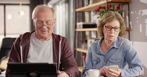 Attractive senior couple using Smartphone and Tablet Stock Footage 82179476