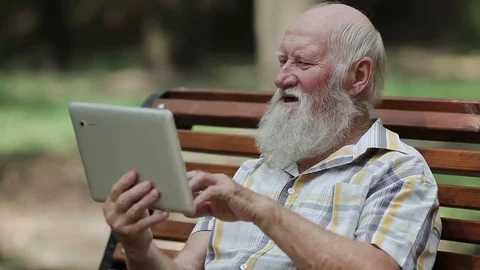 Attractive senior man using tablet on the bench Video stock 80436651