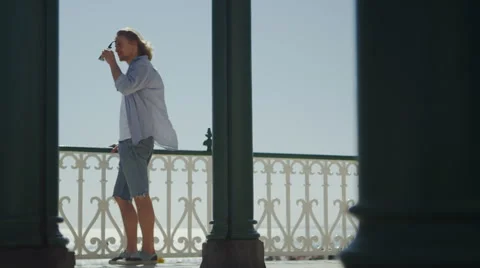 Attractive single man looking out to sea from a balcony Stock Footage 52150092