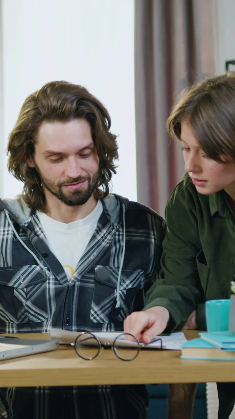 Attractive skilled bearded guy working on laptop at home when beautiful positive Stock Footage 328949595