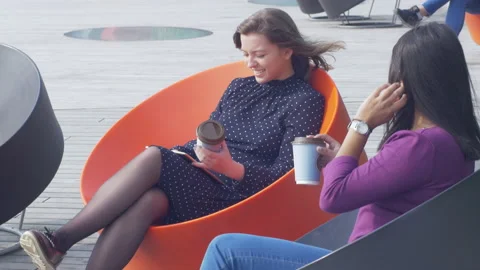 Attractive smiling female using a tablet while chatting with a friend Stock Footage 133062712