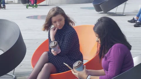 Attractive smiling female using a tablet while chatting with a friend Video stock 133065198