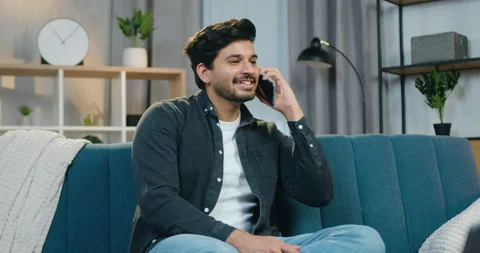 Attractive smiling satisfied young bearded man in casual clothes relaxing on the Stock Footage 150157582