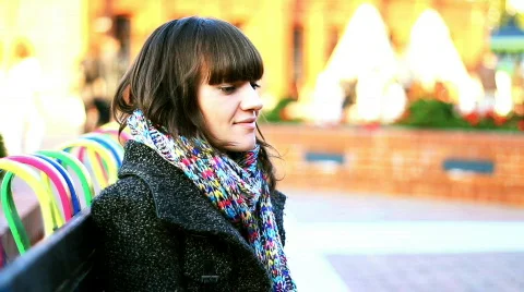 Attractive smiling woman sitting on bench in urban environment Stock Footage
