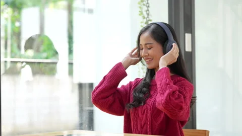 Attractive smiling young woman using tablet and listen music on sofa at home Stock Footage 219556687