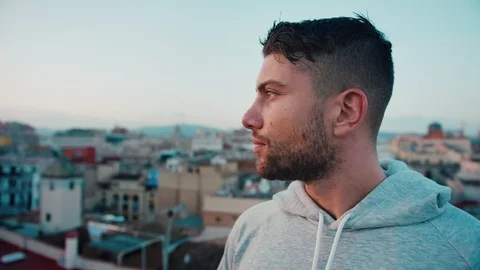 Attractive sport self-secure man face looking or observing sunset on the rooftop Stock Footage 101138848