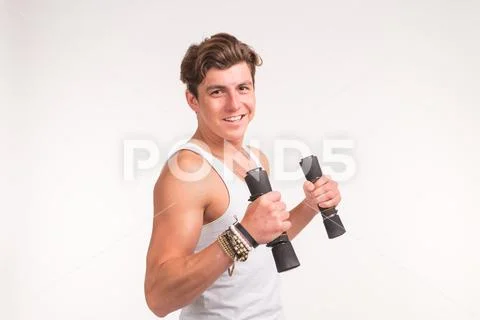 An attractive sporty man shows his biceps and smiling on white background Stock Photos