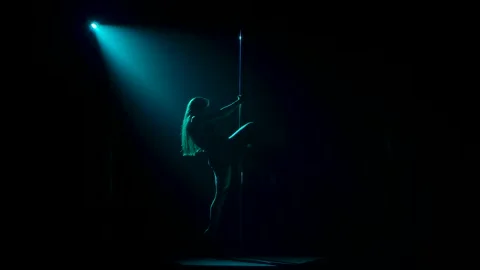 Attractive striptease dancer performs tricks on pole. Silhouette of sexy Stock Footage 150837309