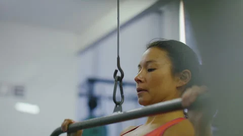 Attractive strong woman using a weights machine in slow motion Stock Footage 47998344