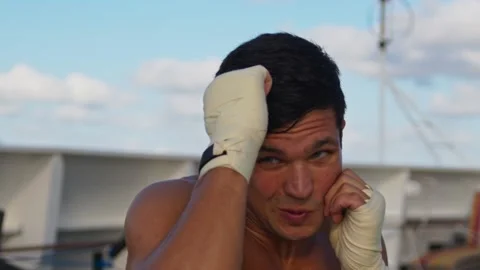 Attractive strong young man does box workout exercising shadow boxing outdoors Stock Footage 193883112