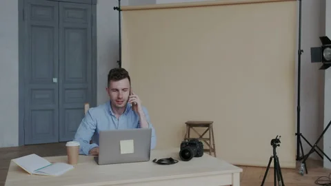 Attractive stylish creative worker or photographer talking on the smartphone and Stock Footage 107779468