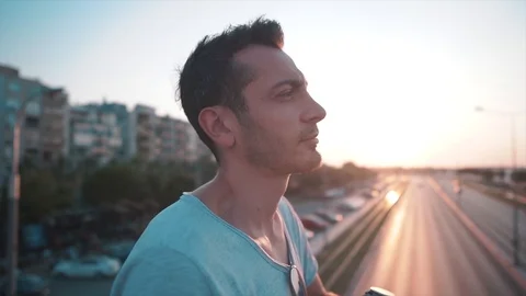 Attractive stylish guy is typing on mobile phone at sunset time.  Video stock 112894926