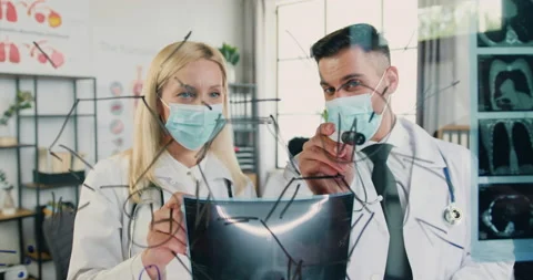 Attractive successful qualified two doctors-man and woman in protective masks Stock Footage 160351966