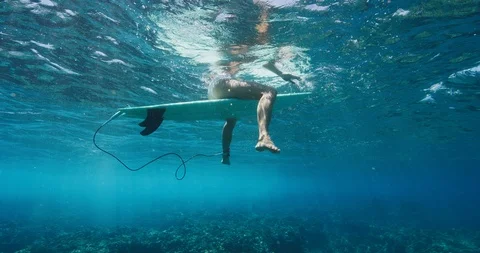 Attractive surfer sitting on her surfboard Stock Footage 107969759