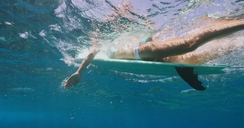 Attractive surfer sitting on her surfboard Stock Footage 107977507