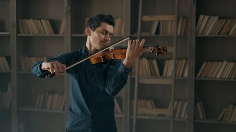 Attractive talented young man playing violin sensually. The violinist rehearses Stock Footage 104297567