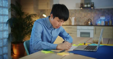 Attractive thoughtful Korean guy using notebook working on creative business Video stock 124325969