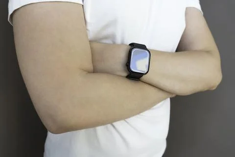 Attractive unknown man in white t-shirt sporting a smartwatch, smart watch .. Stock Photos