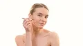 The attractive woman applying makeup on her face on the white background 4k or 4k+ Resolution