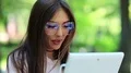 Attractive woman in big glasses uses tablet computer HD Footage
