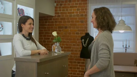 Attractive woman comes to jewelry store and talking to young seller consultant Stock Footage