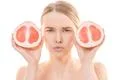 The attractive woman holding a grapefruit on the white background Photo