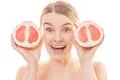 The attractive woman holding a grapefruit on the white background Photo