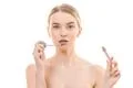 The attractive woman holding a lip gloss on the white background Photo