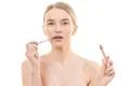 The attractive woman holding a lip gloss on the white background Photo