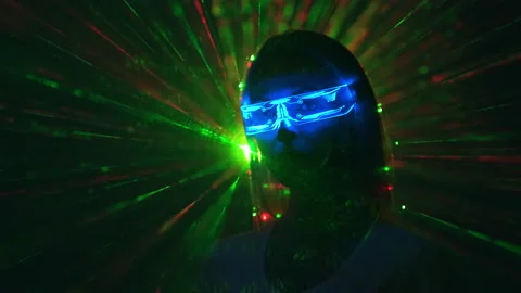 The attractive woman in interactive glasses on a color rays background Stock Footage 191441853