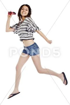 Attractive woman jumping against white background. Stock Photos
