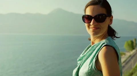 Attractive woman looking to the camera while standing next to the seaside 動画素材 66764462