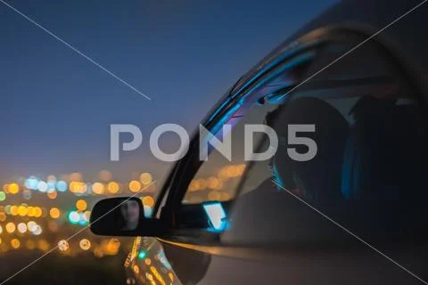 The attractive woman phone in the car on the background of the city. night ti Stock Photos