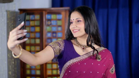 An attractive woman posing happily while clicking a selfie using her smartpho... Stock Footage 170281596