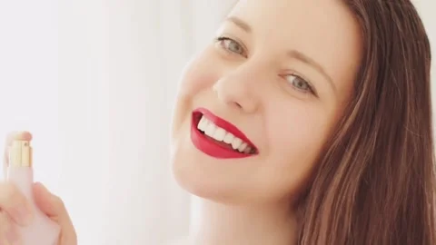 Attractive woman presenting perfume with fresh new rose scent, floral fragrance Vídeo Stock 152852653