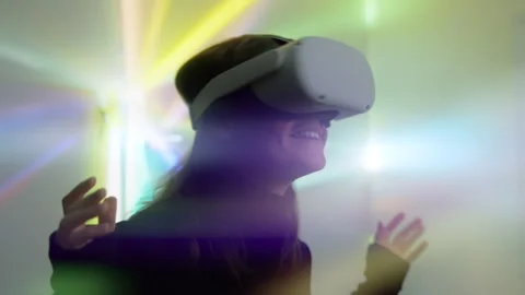 Attractive woman puts on virtual reality headset and dives in 3D world smiling Vídeo Stock 242507053