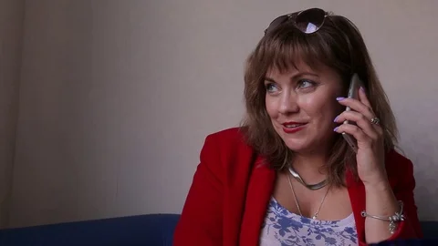 Attractive Woman in red jacket using Mobile Phone During sitting anywhere Stock Footage 99258196